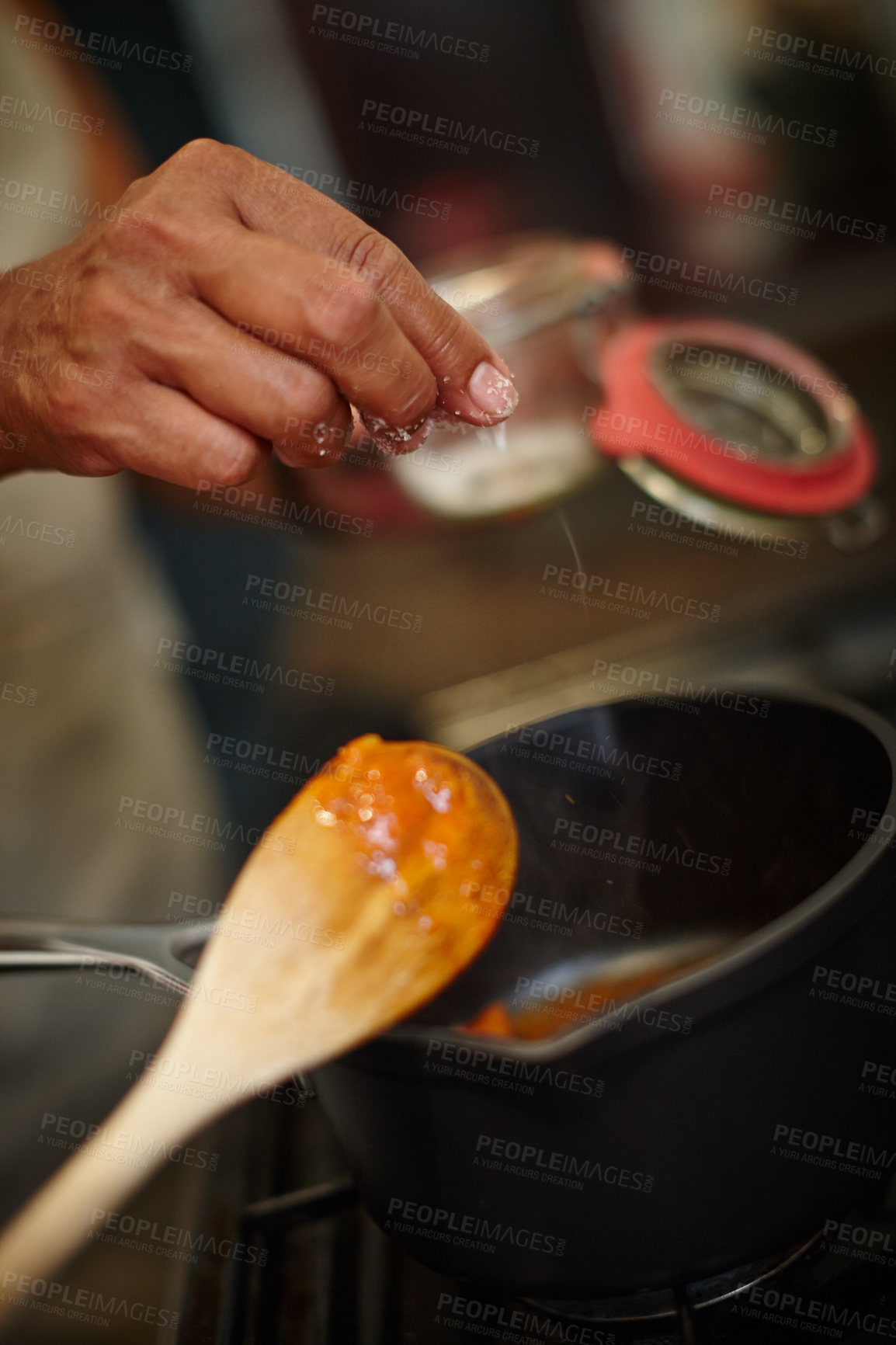 Buy stock photo Closeup shot of a woman adding salt to the pot on the stove