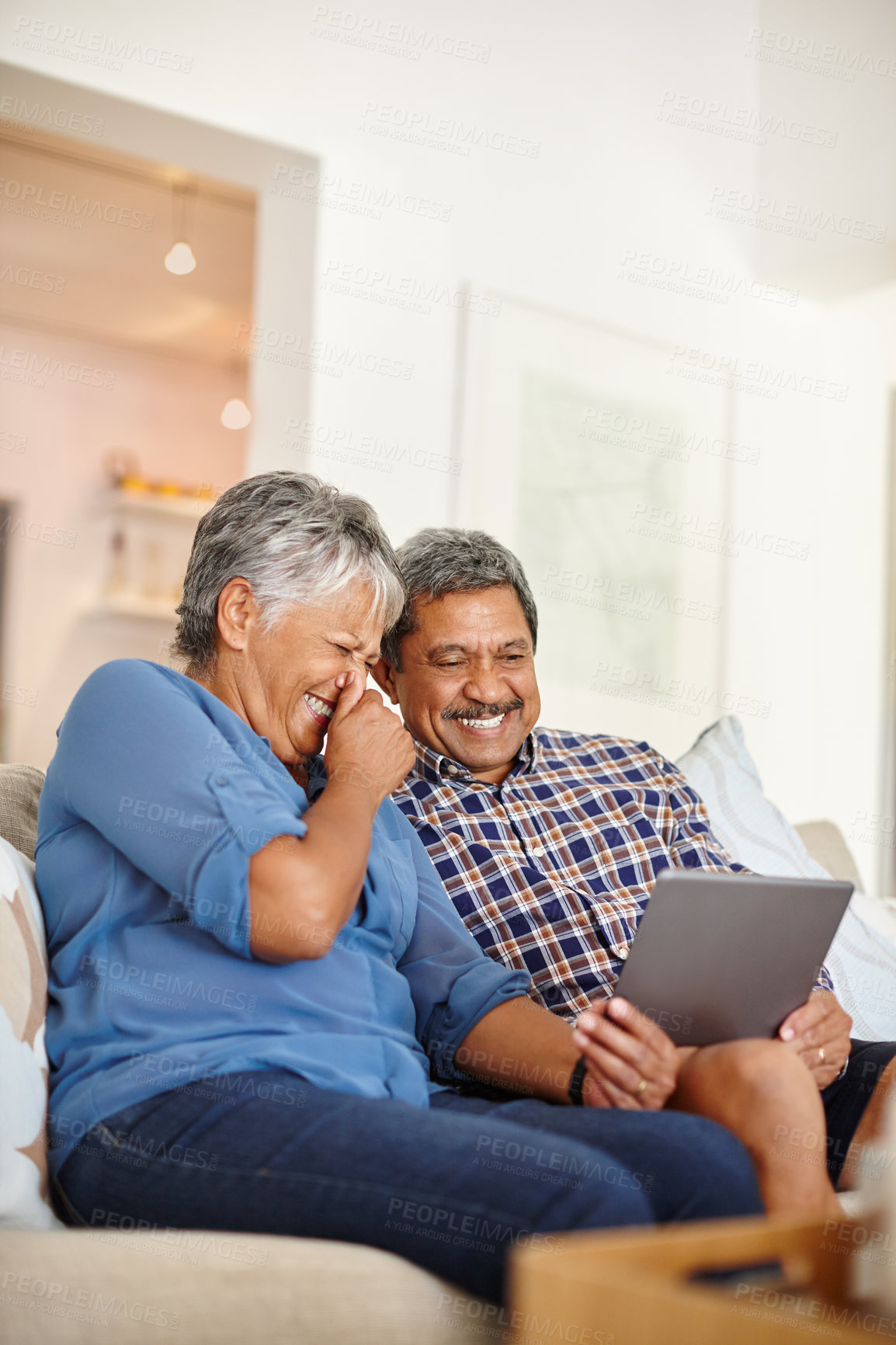Buy stock photo Shot of a happy senior couple using a digital tablet together at home