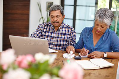 Buy stock photo Shot of a senior couple working on their budget together at home