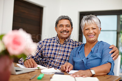 Buy stock photo Shot of a happy senior couple working on their budget together at home