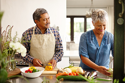 Buy stock photo Food, elderly couple and cooking while happy in kitchen of their home. Teamwork or help, vegetables and senior married people preparing a meal for dinner or lunch together in their house.