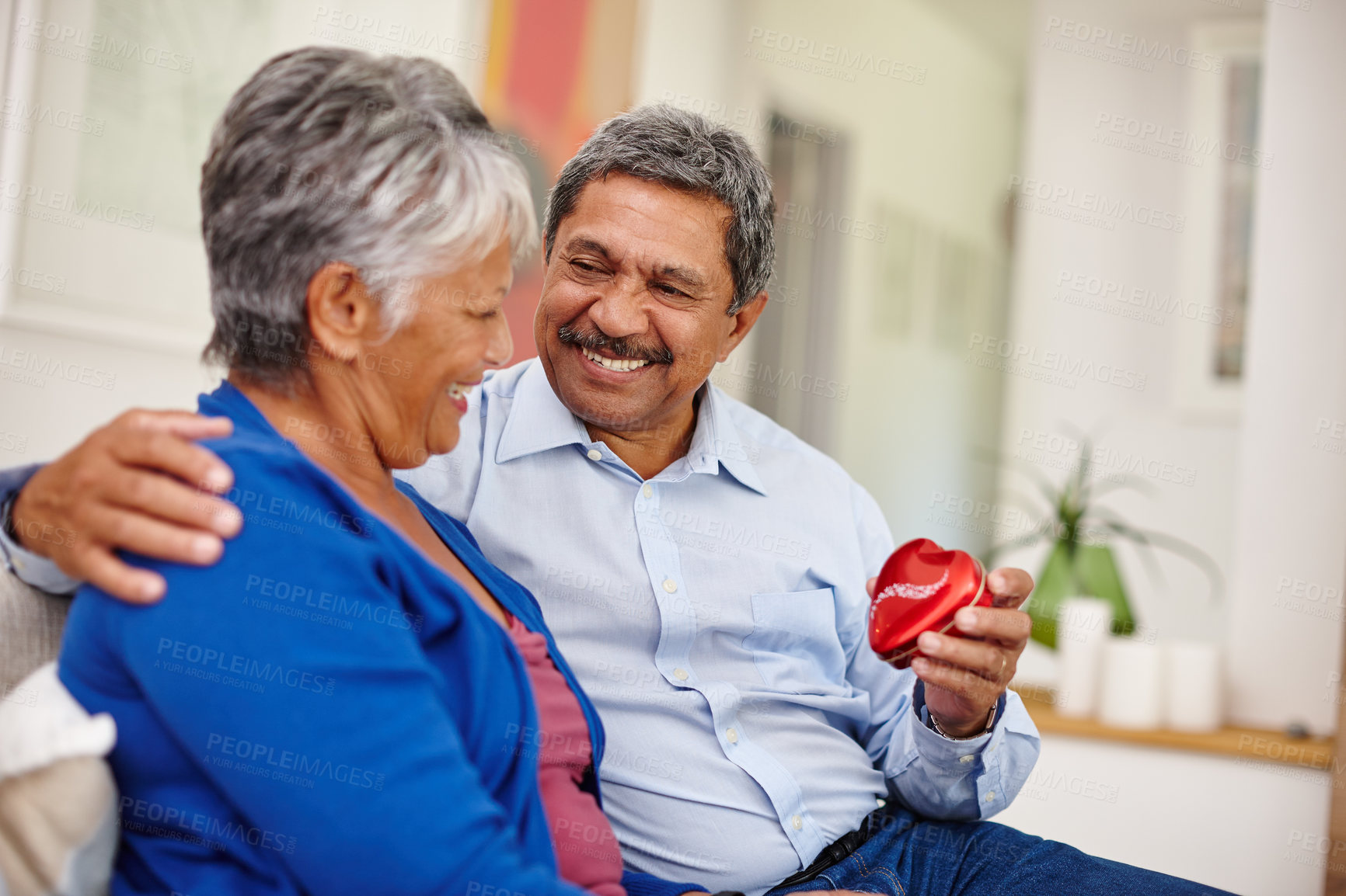 Buy stock photo Shot of a loving senior man giving his wife a gift for Valentine's Day