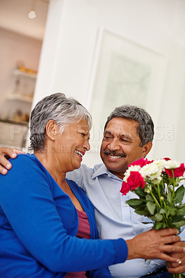 Buy stock photo Shot of a loving senior man giving his wife a bunch of flowers