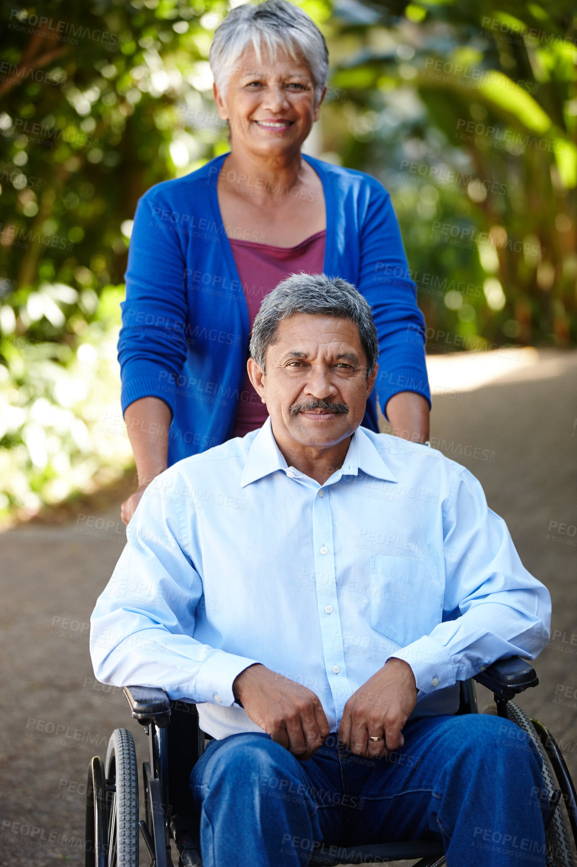 Buy stock photo Portrait of a senior woman pushing her husband in a wheelchair outdoors