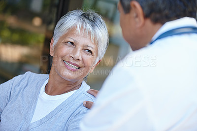 Buy stock photo Senior, smile and woman talking to her doctor, consultation or conversation. Consulting, medical professional and female person in discussion with healthcare physician for health, wellness or checkup