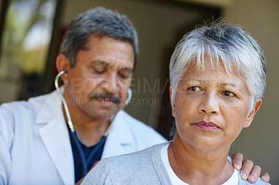 Buy stock photo Cropped shot of a senior woman getting a checkup from her doctor at home