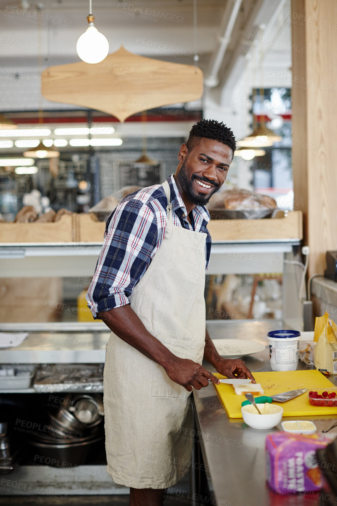 Buy stock photo Cropped portrait of a handsome young man preparing food in the kitchen of his cafe