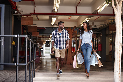 Buy stock photo Shot of a woman holding shopping bags while walking with her boyfriend