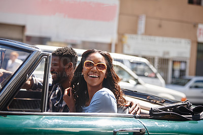 Buy stock photo A happy young couple driving in a convertible on a bright summer's day