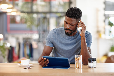 Buy stock photo Cropped shot of a handsome man sitting in a coffee shop using a cellphone and tablet