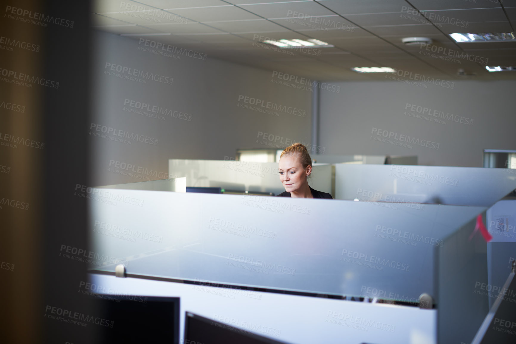 Buy stock photo Cropped shot of an attractive young woman standing in her office cubicle
