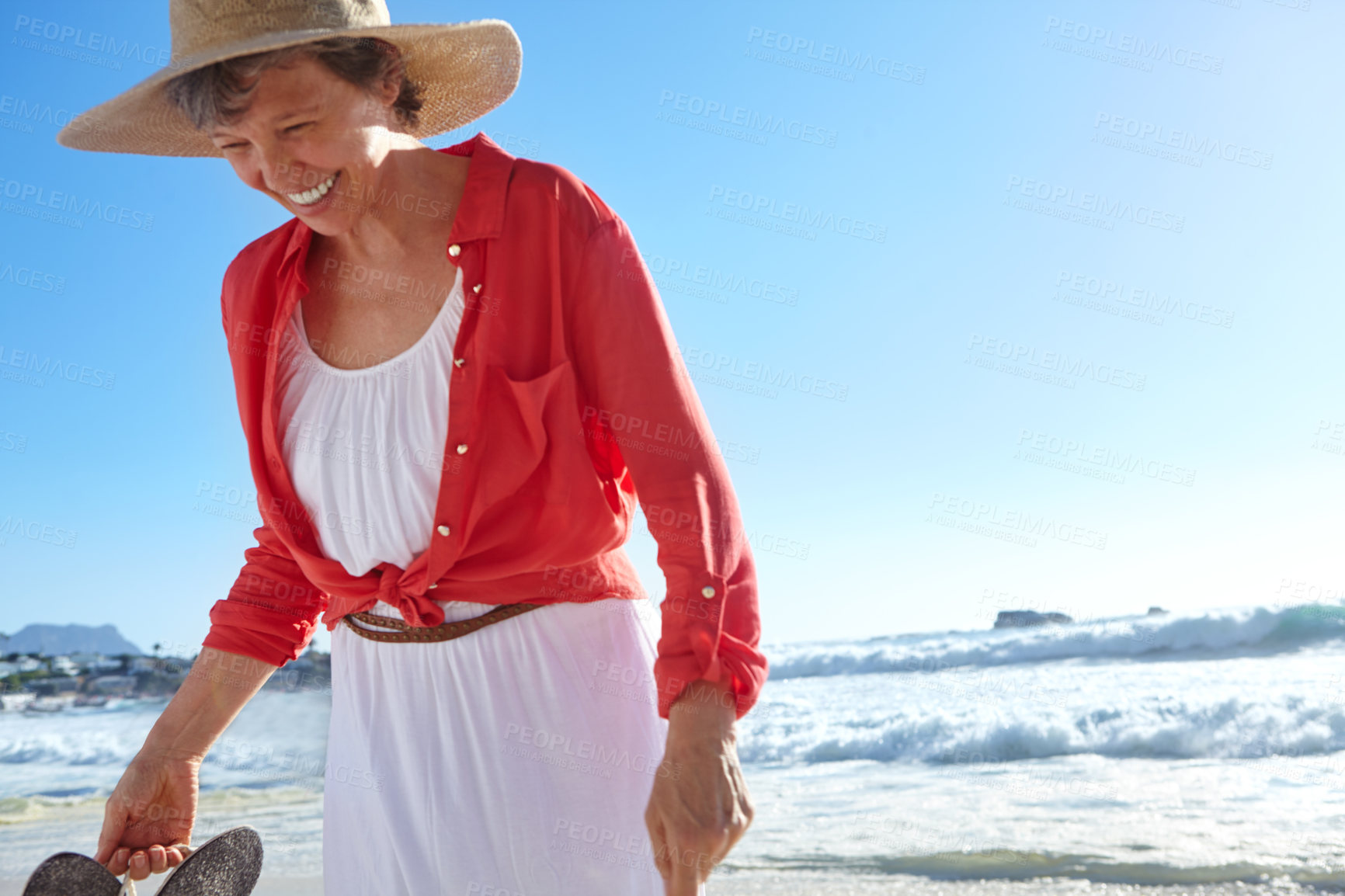 Buy stock photo Shot of an attractive mature woman enjoying a day at the beach