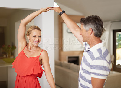 Buy stock photo Shot of a happily married couple dancing together at home