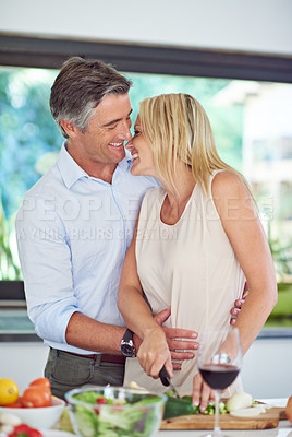 Buy stock photo Married couple, kiss and cooking in kitchen for dinner preparation, anniversary and support. Mature man, wife and cutting vegetable in home for healthy meal, milestone celebration or love in marriage