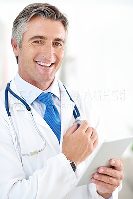 Buy stock photo Portrait of a doctor holding a digital tablet while standing in a hospital corridor