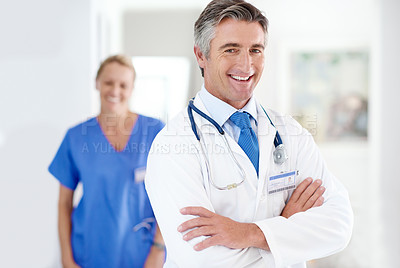 Buy stock photo Portrait of a male doctor with a colleague standing in a the background