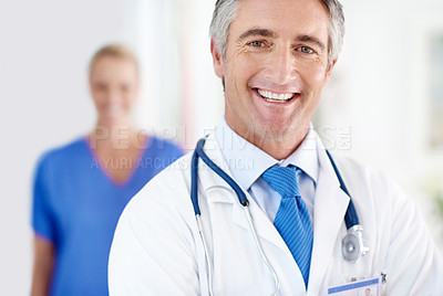 Buy stock photo Portrait of a male doctor with a colleague standing in a the background