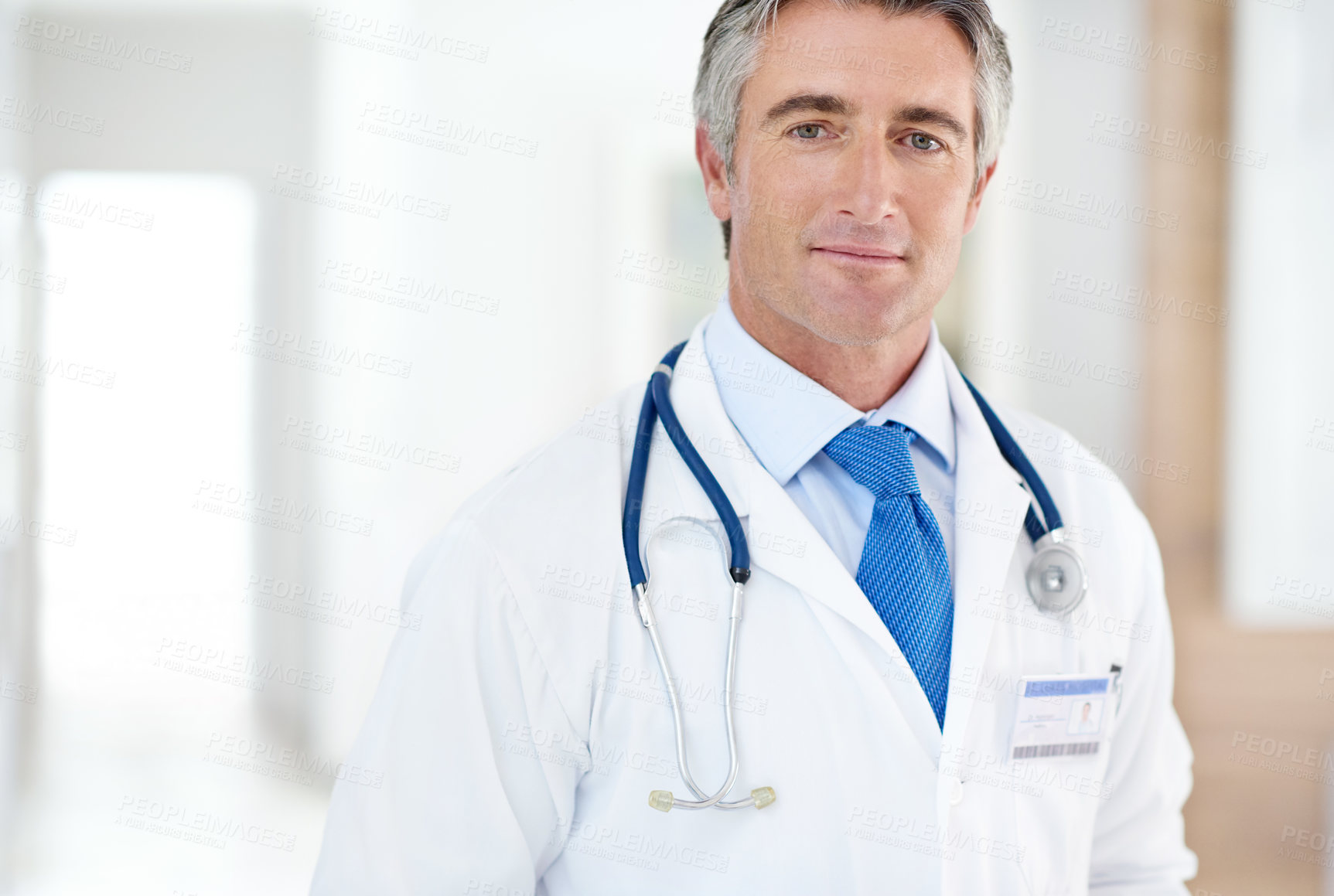 Buy stock photo Portrait of a male doctor standing in a hospital corridor