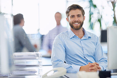 Buy stock photo Portrait of a handsome young businessman sitting at his office desk