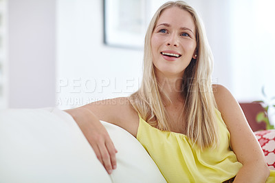 Buy stock photo Shot of an attractive young woman relaxing on her sofa at home