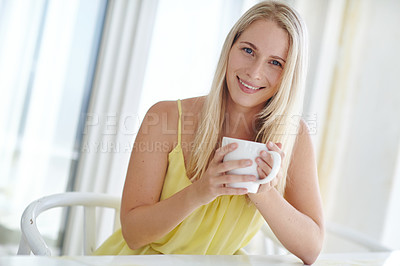 Buy stock photo Shot of an attractive young woman drinking a coffee at home