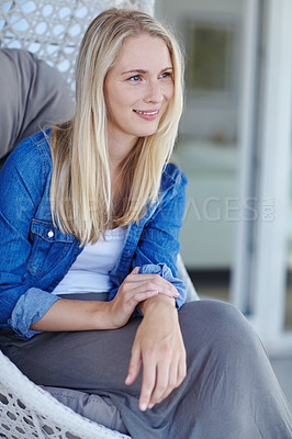 Buy stock photo Shot of an attractive young woman relaxing in a hanging basket chair on her patio