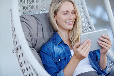 Buy stock photo Shot of an attractive young woman relaxing in a hanging basket chair on her patio