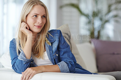 Buy stock photo Shot of an attractive young woman relaxing on her sofa at home