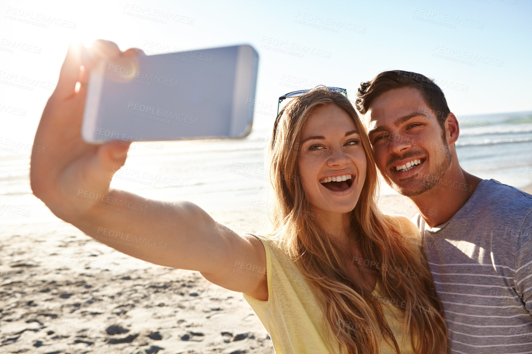 Buy stock photo Cropped shot of an affectionate young couple taking a selfie on the beach