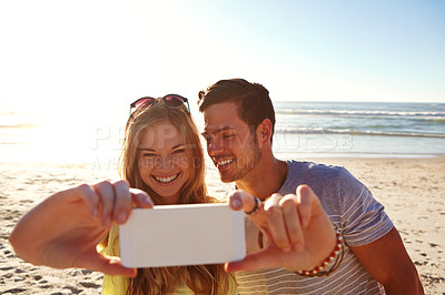 Buy stock photo Cropped shot of an affectionate young couple taking a selfie on the beach