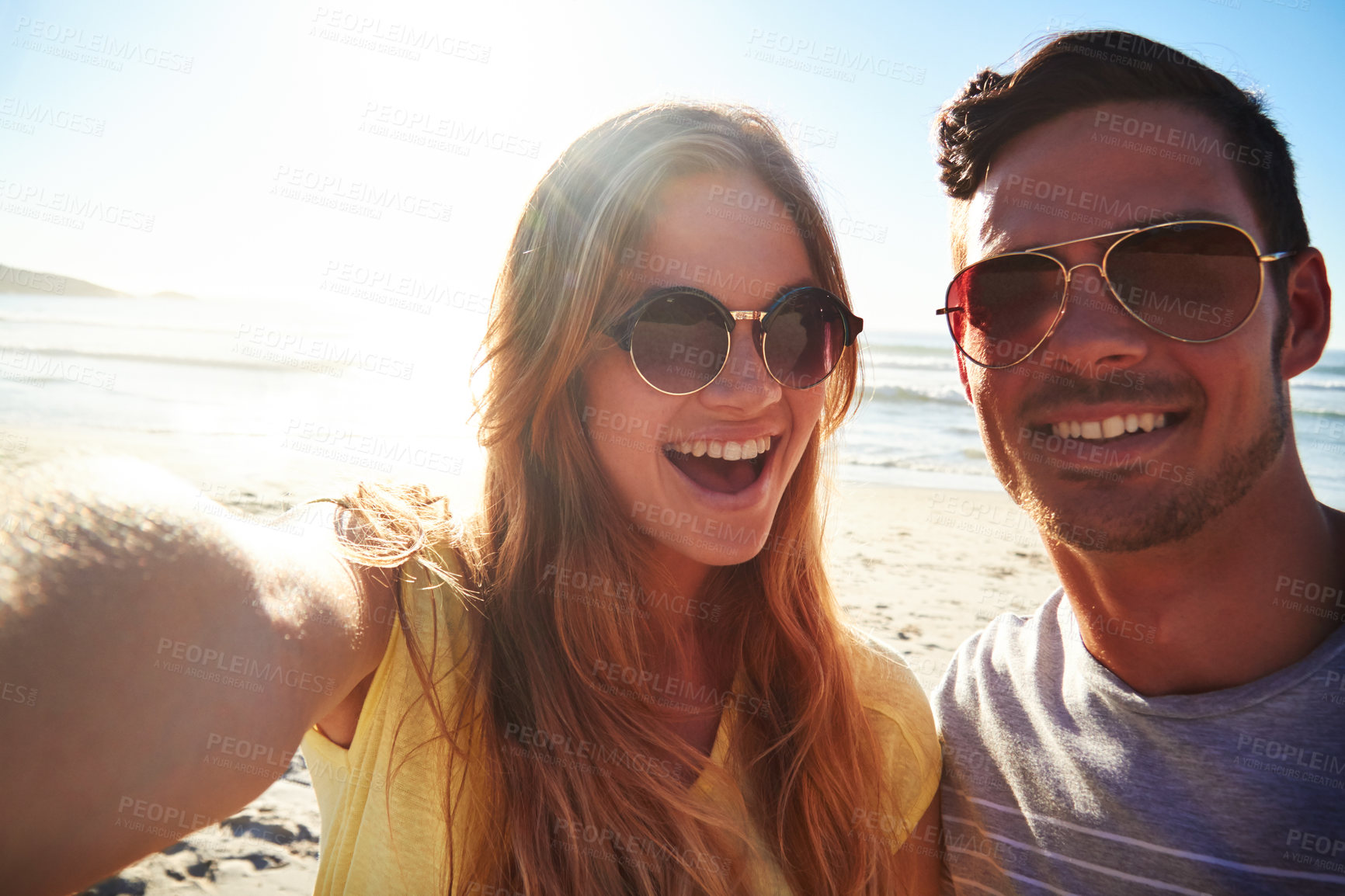 Buy stock photo Cropped shot of an affectionate young couple taking a selfie on the beach