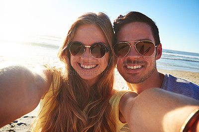 Buy stock photo Cropped shot of an affectionate young couple taking a selfie on the beach