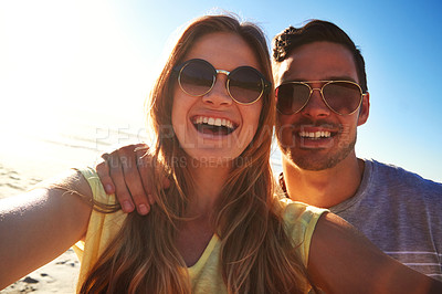 Buy stock photo Cropped shot of an affectionate young couple taking a selfie on the beach