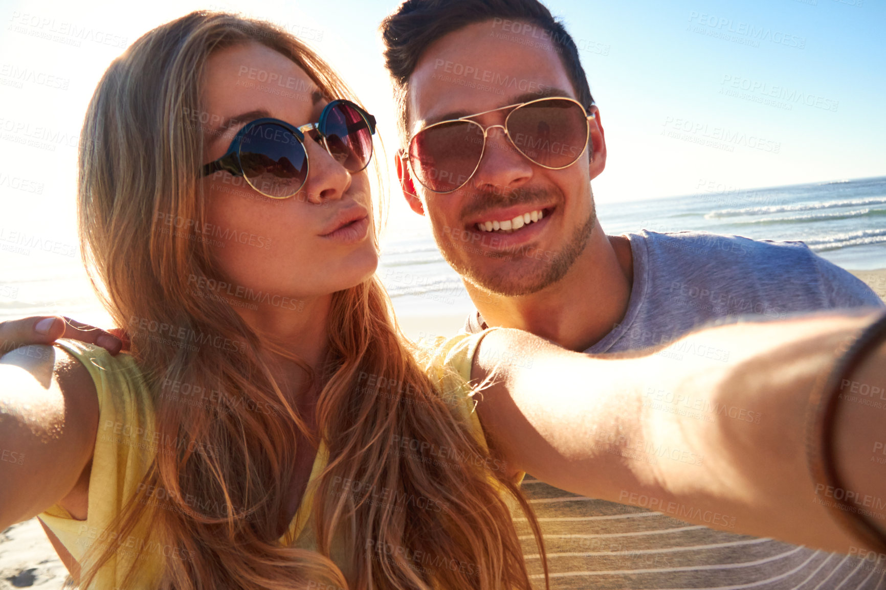 Buy stock photo Cropped shot of an affectionate young couple taking a selfie on the beach