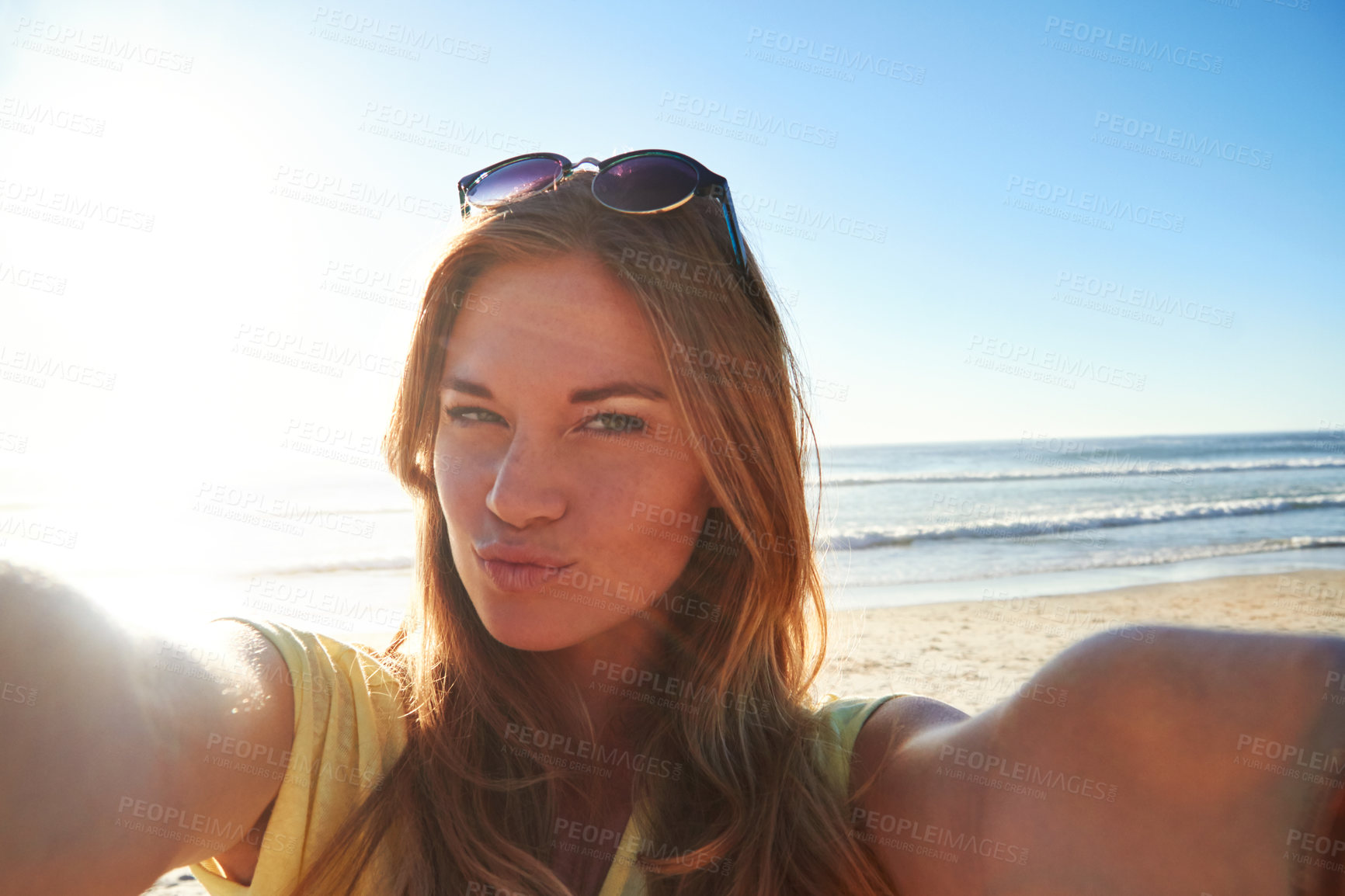 Buy stock photo Cropped shot of an attractive young woman taking a selfie on the beach
