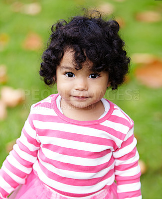 Buy stock photo Nature, portrait and girl child in a garden play with toy on the grass on summer weekend. Adorable, playful and young kid, baby or toddler with curly hair sitting on the lawn in outdoor field or park