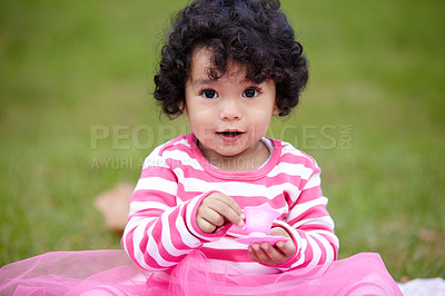 Buy stock photo Nature, portrait and girl kid in a garden play with toy on the grass on summer weekend. Adorable, playful and young child, baby or toddler with curly hair sitting on the lawn in outdoor field or park