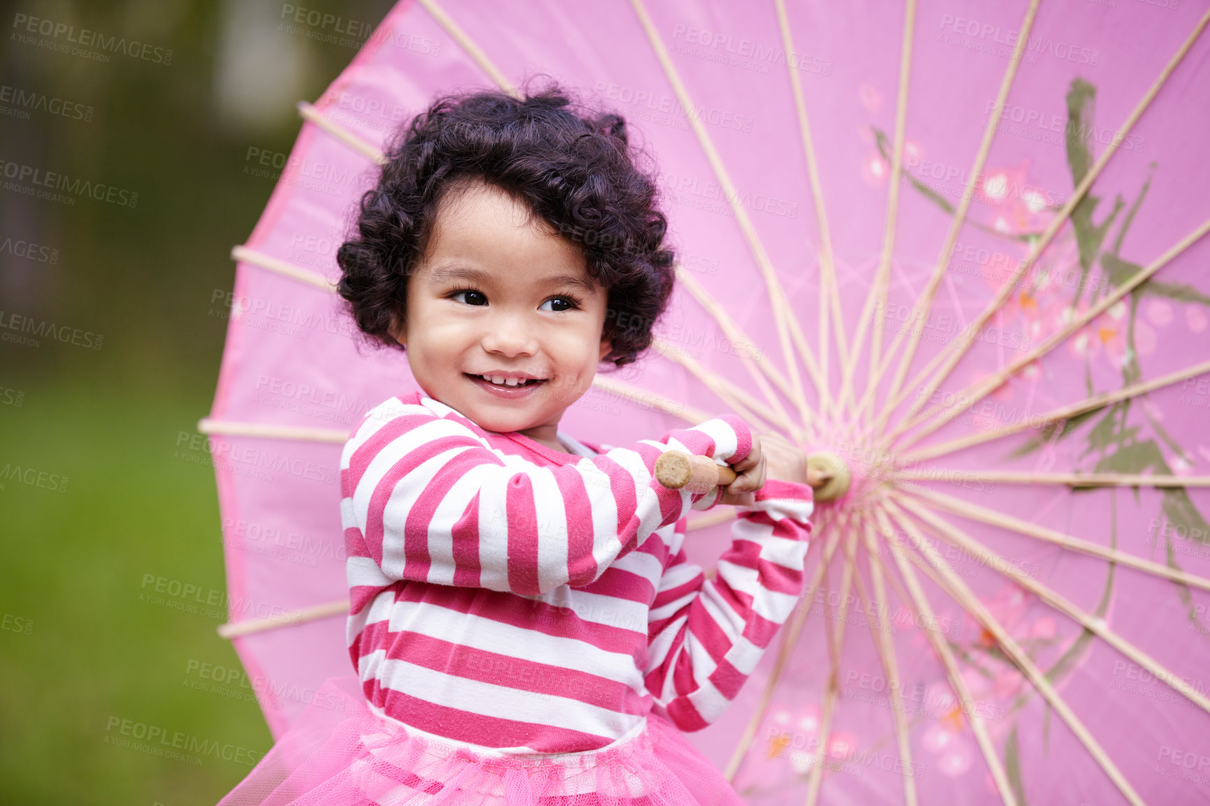 Buy stock photo Umbrella, happy and girl child in a garden walking on the grass on summer weekend. Adorable, playful and young kid, baby or toddler with curly hair playing on the lawn in outdoor field or park.