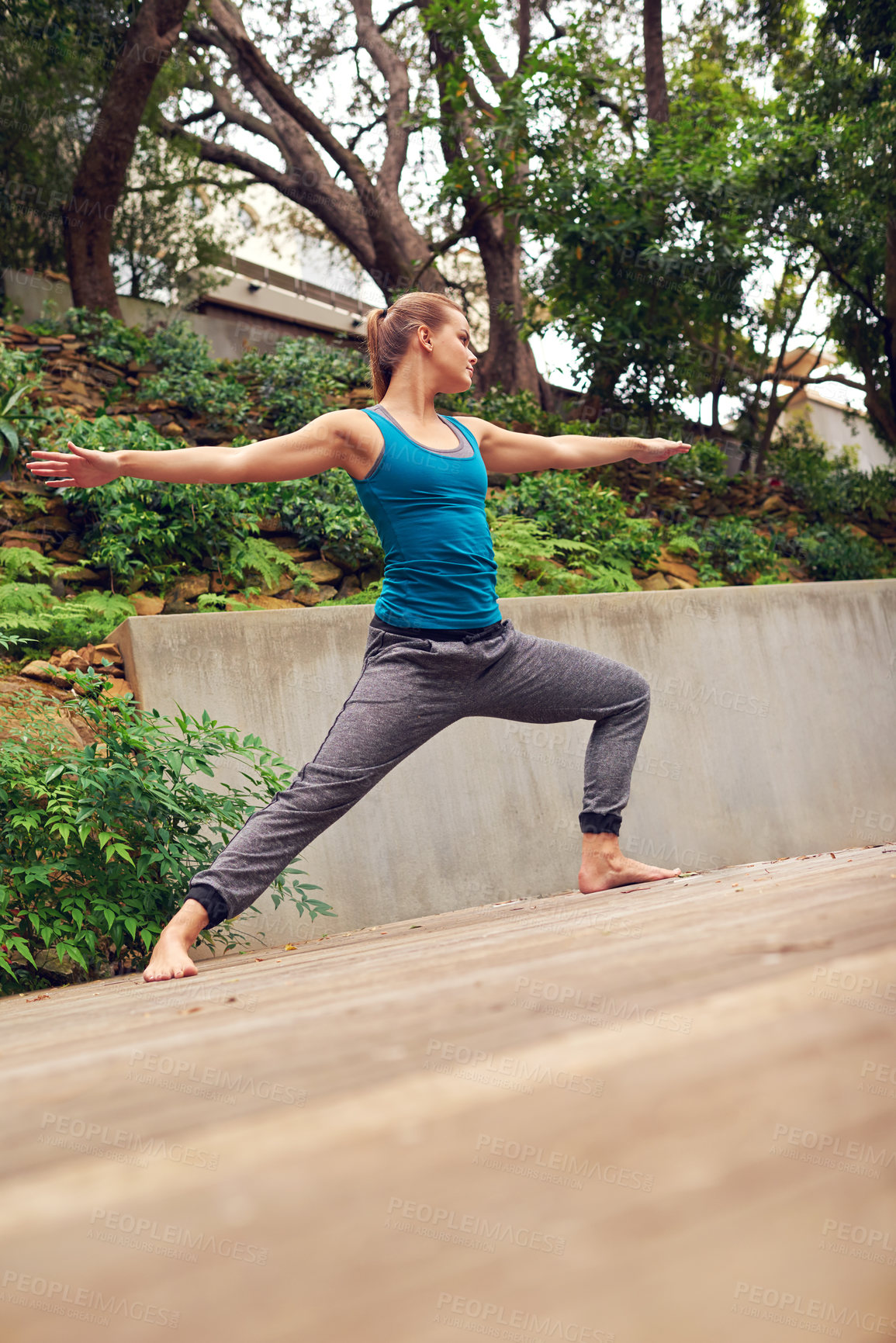 Buy stock photo Woman, yoga and patio with relax, warrior pose and balance on garden deck outside home. Zen, heath and wellness with holistic practice, posture and wood floor with body health, plants and flexibility