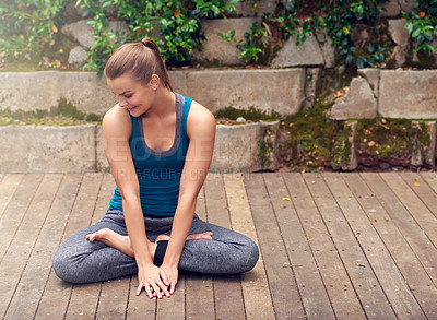 Buy stock photo Shot of a young woman practicing yoga outdoors