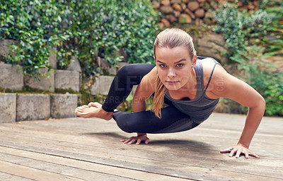 Buy stock photo Shot of a young woman practicing yoga outdoors