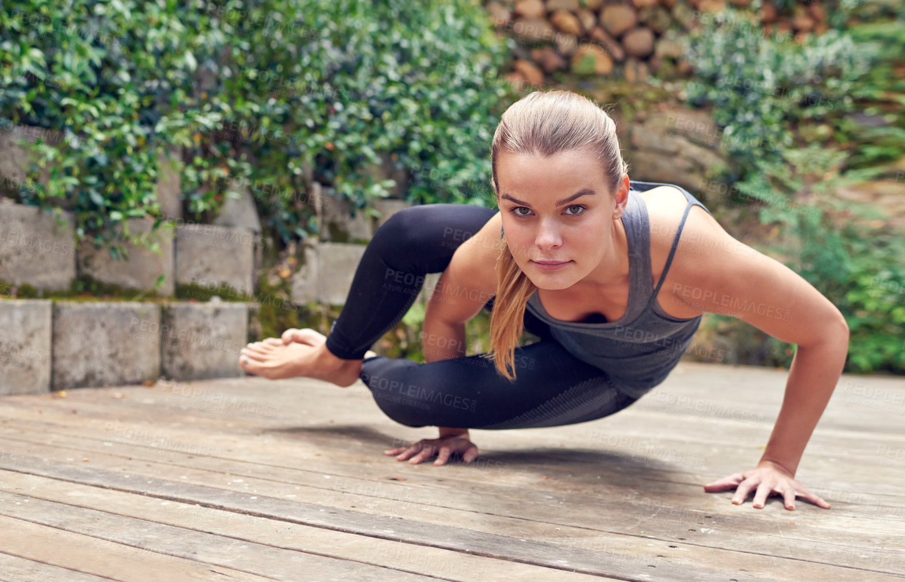 Buy stock photo Shot of a young woman practicing yoga outdoors