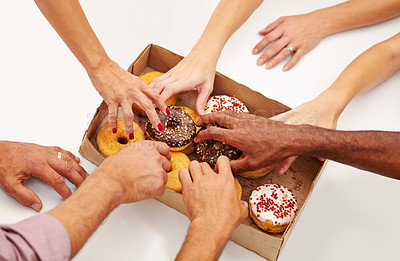 Buy stock photo A multitude of hands reaching to grab a doughnut from a box