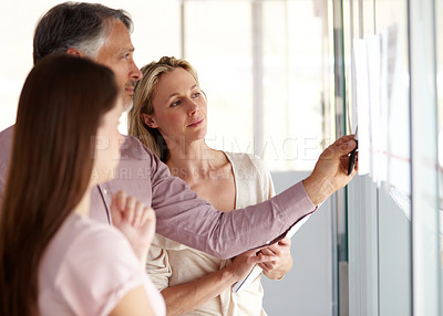 Buy stock photo Business people, teamwork and meeting for schedule planning, brainstorming or collaboration at office. Businessman and team looking at project plan on glass board for agenda or tasks at workplace