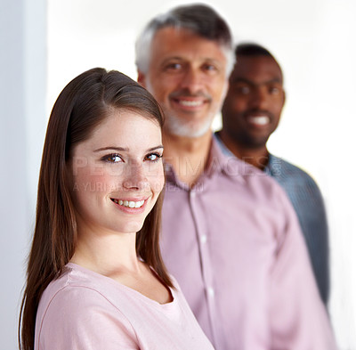 Buy stock photo Portrait of an attractive young businesswoman with her colleagues standing behind her