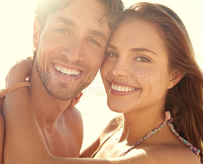 Buy stock photo Sunset, portrait and happy couple hug at a beach for summer, adventure or vacation while bonding in nature. Face, smile and people at sea with support, trust and love at sunrise, journey or holiday