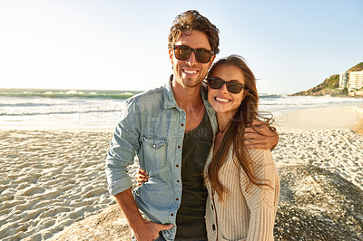 Buy stock photo Couple, beach and sunglasses with hug, smile and care with fashion, eye protection and vacation in summer. Man, woman and embrace with glasses for sun, trendy style and together with love on holiday