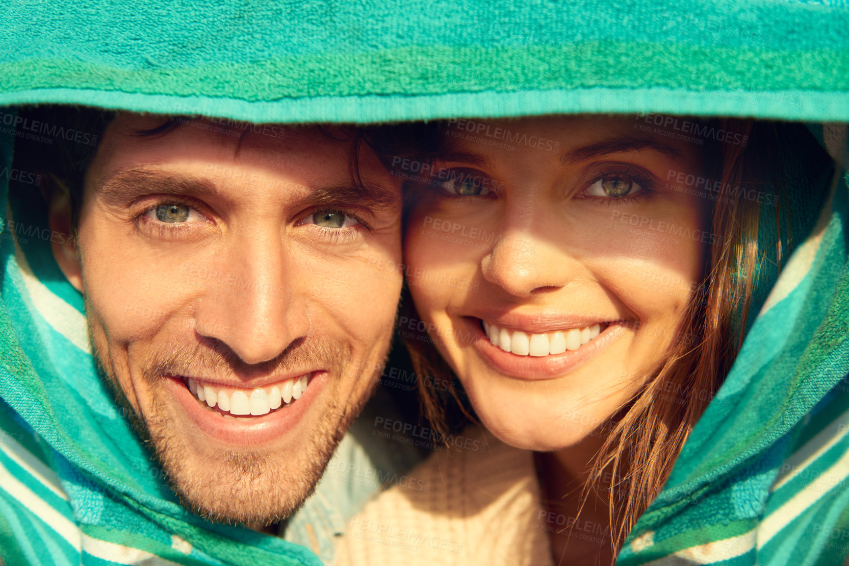 Buy stock photo Man, woman and beach towel for protection or portrait together for weekend, bonding or embrace. Happy couple, face and hugging for warm comfort for weather or love trip for adventure, outdoor or fun