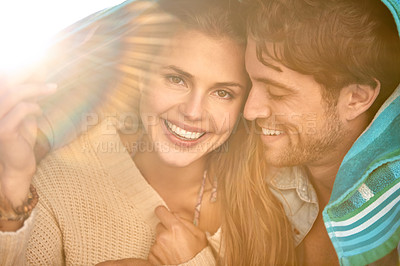 Buy stock photo Couple, beach and cover with towel for protection from cold in environment for weather, sun or wind. Man, woman and happy shelter for outdoor adventure or relax vacation for bonding, marriage or trip