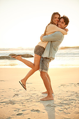 Buy stock photo Smile, hug and portrait of couple at beach on vacation, adventure or holiday for valentines day. Sunset, love and man carry, embrace and bond with woman by ocean for weekend trip on romantic date.